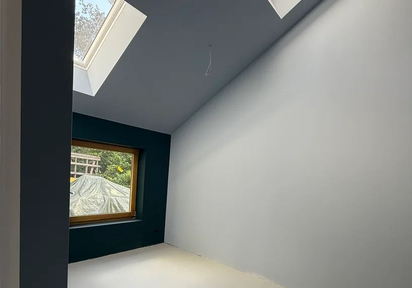 Zwart geschilderde trap met balustrade in een lichte hal