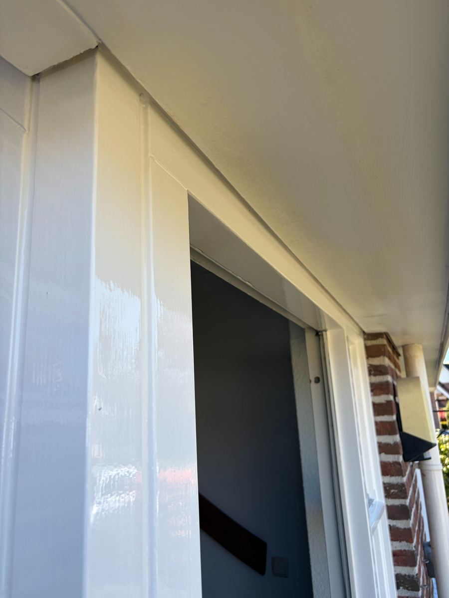 Wit geschilderde onderdorpel en houtwerk bij een garagepoort