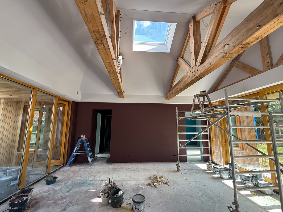 Grote woonruimte onder de houten kap tijdens het schilderwerk